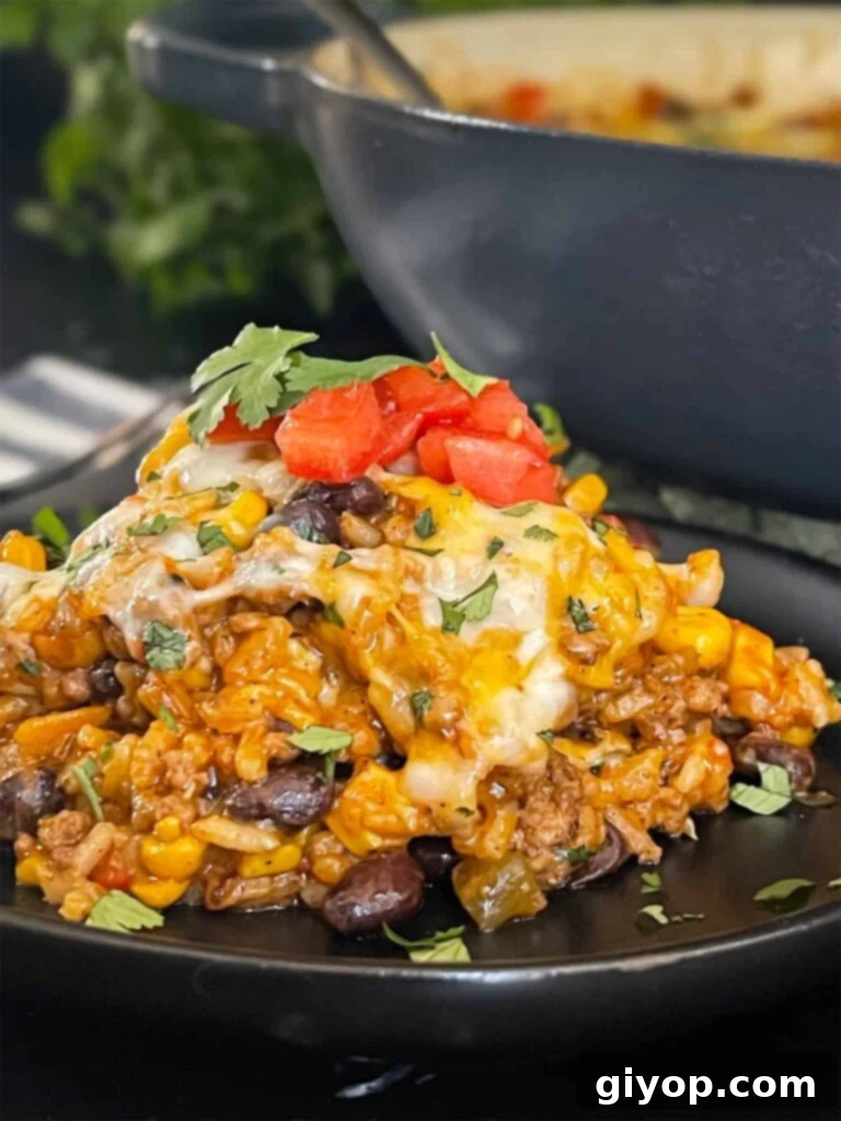 Another perspective of the Mexican ground beef casserole with rice on a dark plate, showcasing its rich texture.