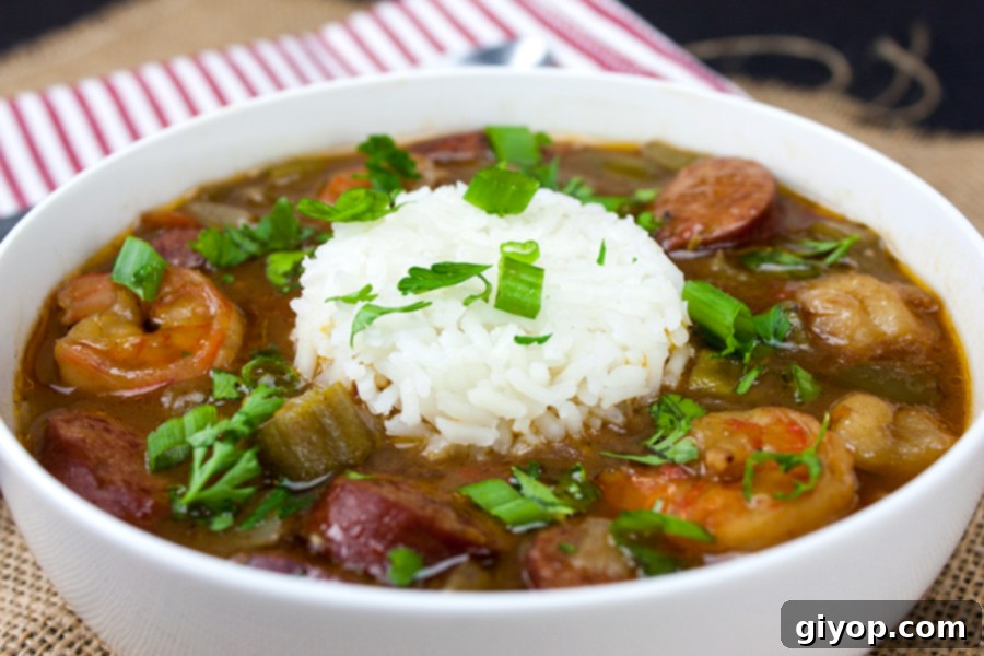 Louisiana Surf and Turf Gumbo 3 A close-up shot of rich gumbo with rice, brimming with shrimp and sausage, served in a pristine white bowl.