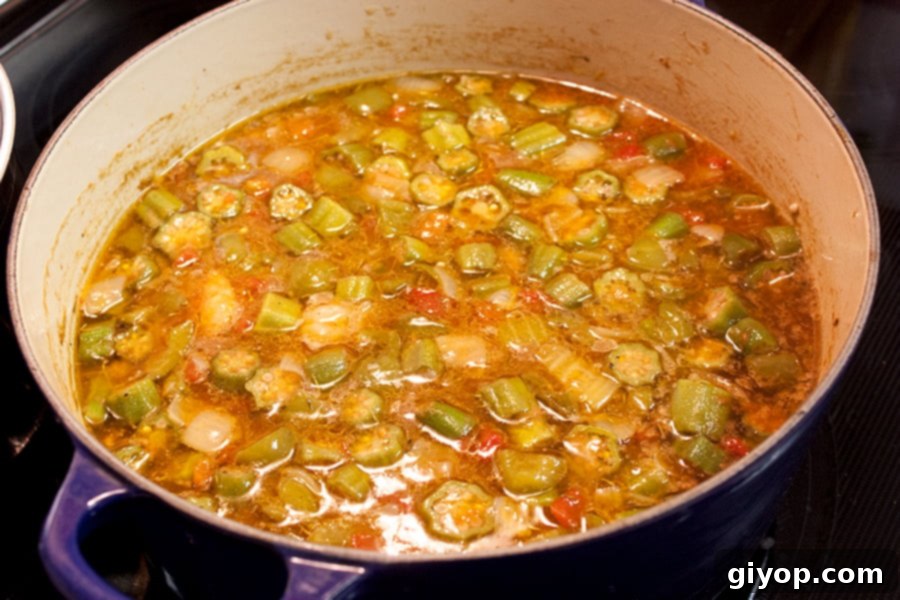 Louisiana Surf and Turf Gumbo 7 The gumbo simmering gently in a Dutch oven, rich and fragrant with layered flavors.