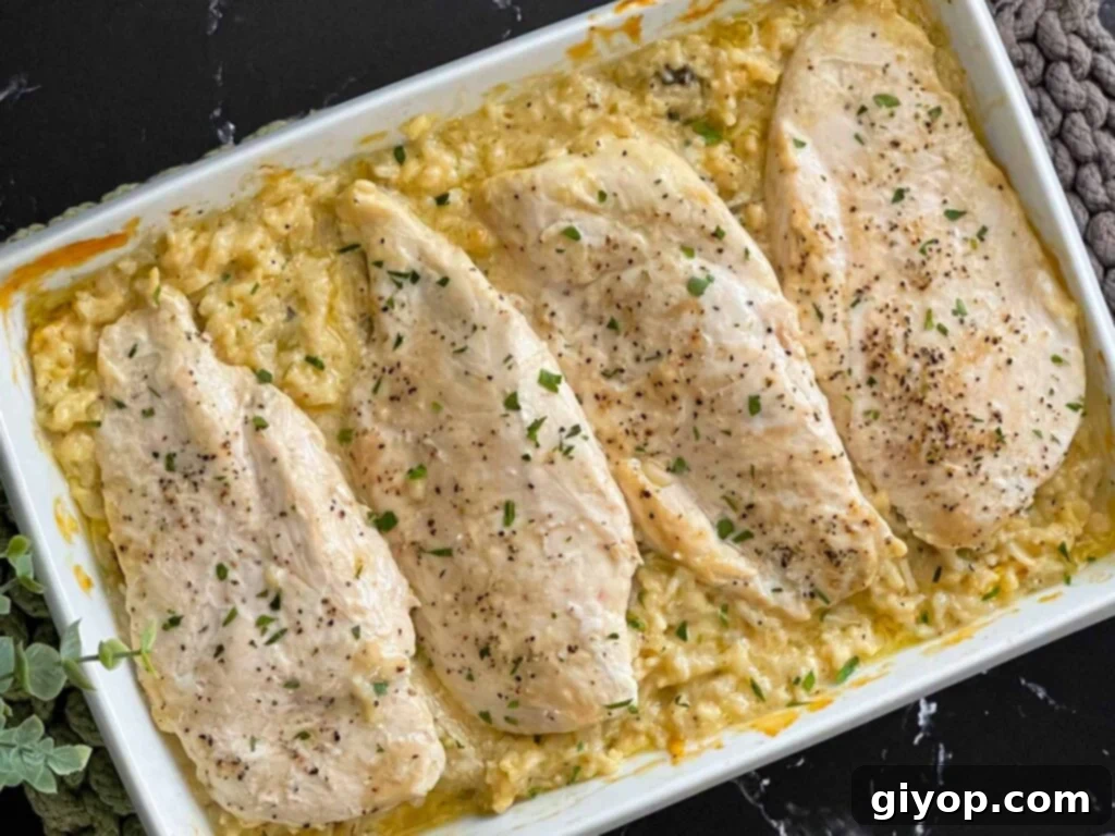 Chicken and rice casserole in a light baking dish on a dark surface.