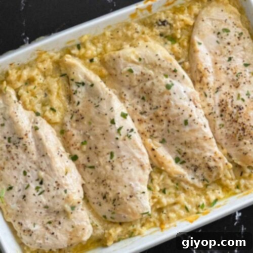 Chicken and rice casserole in a light baking dish on a dark surface.
