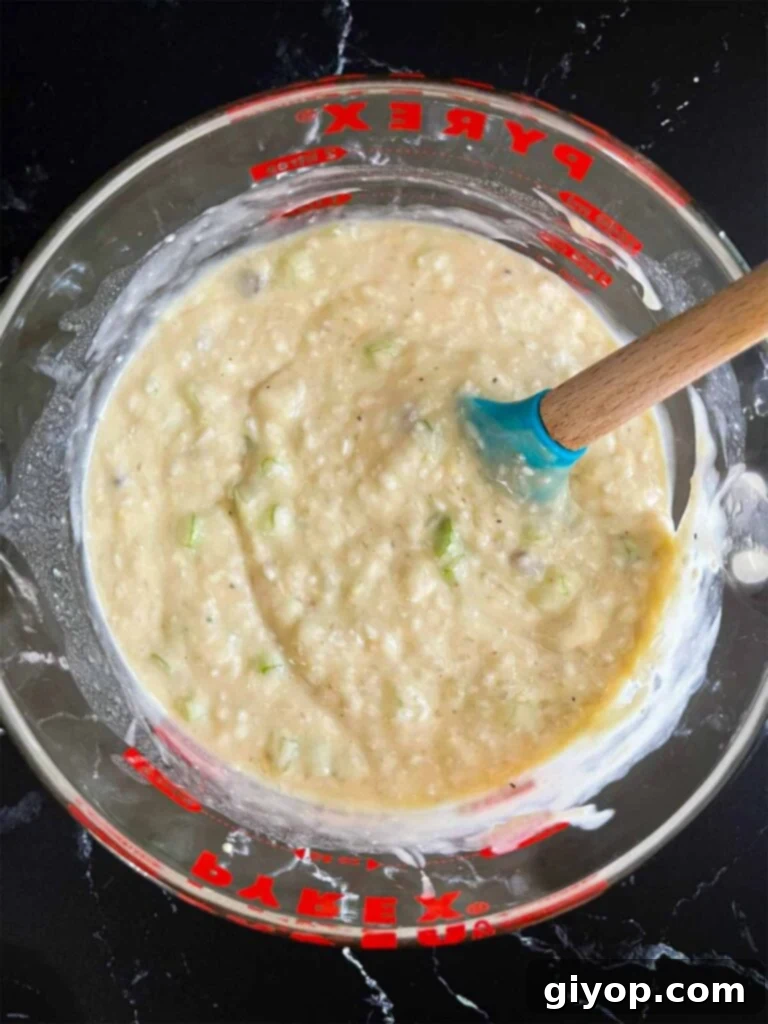 Soup, celery, and rice mixture in a large glass measuring cup.