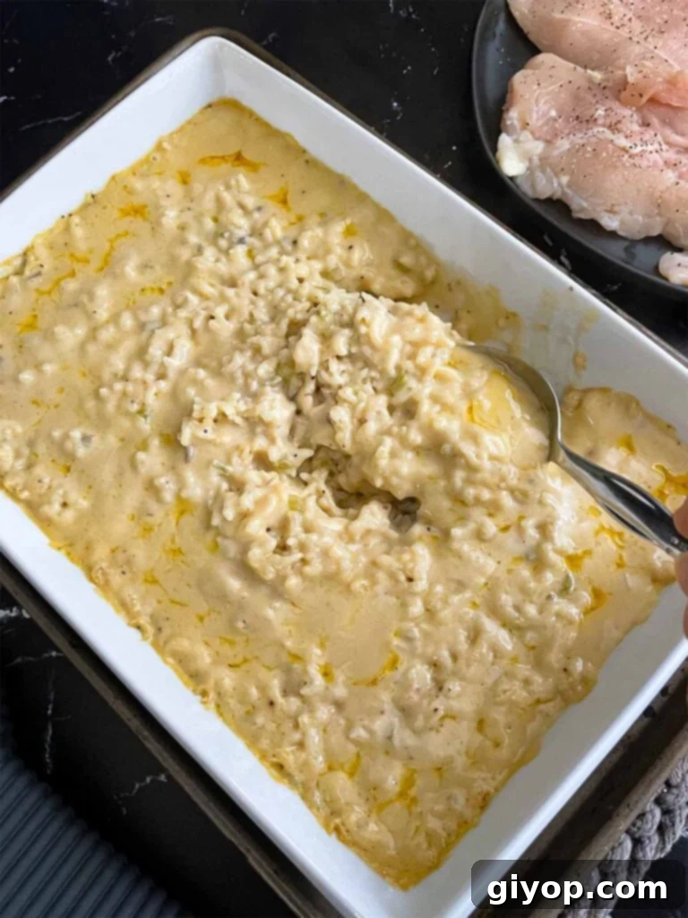 Stirring the chicken and rice casserole after baking for an hour and a half.