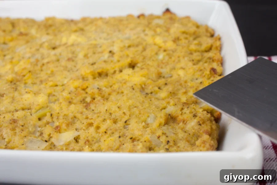 Southern cornbread dressing, freshly baked to a golden brown perfection, sitting in a white casserole dish.
