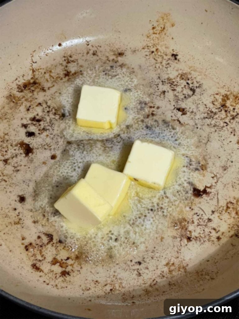Unsalted butter melting in a hot skillet, forming the rich base for the piccata sauce.