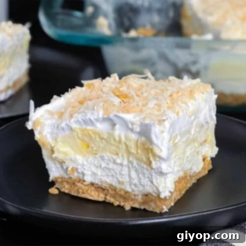 Velvet Coconut Dream 12 A detailed image of a slice of Coconut Cream Lush, showcasing its beautiful layers, on a dark plate against a dark background.