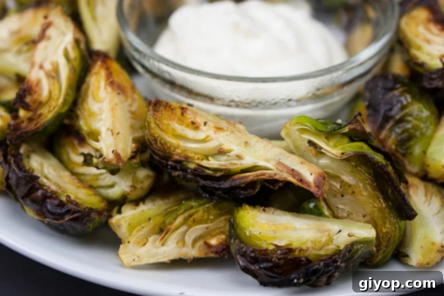 Roasted Brussel Sprouts with Aioli Dipping Sauce served on a white plate.