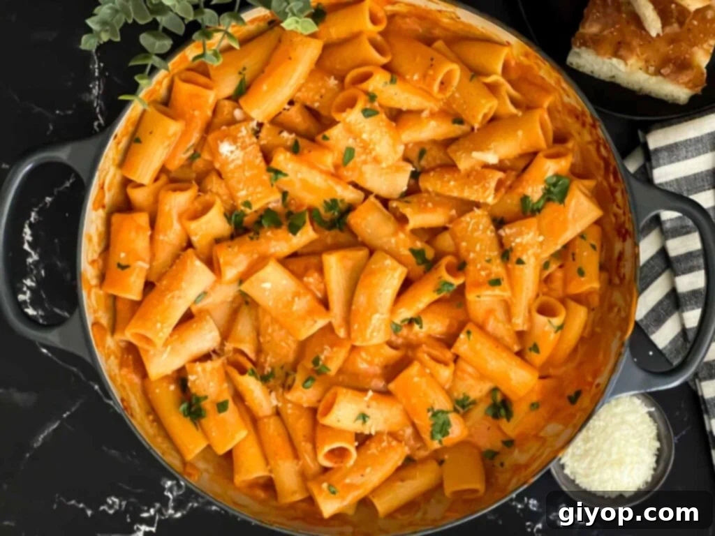 Pasta alla vodka in a skillet, garnished with fresh basil.