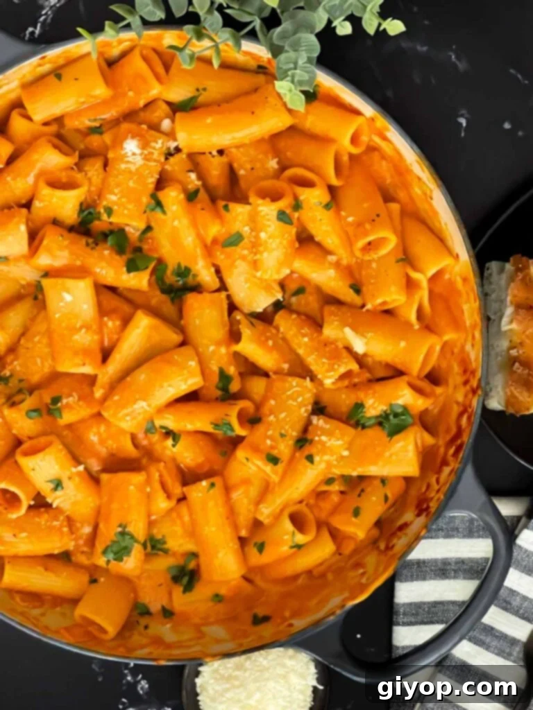 Pasta alla vodka in a skillet, garnished with fresh herbs.