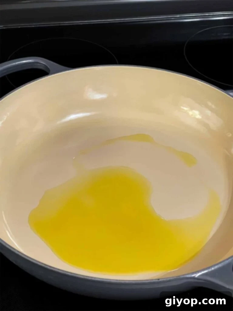 Olive oil heating in a skillet before adding aromatics.