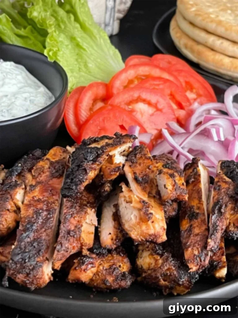 Grilled chicken shawarma on a dark plate.