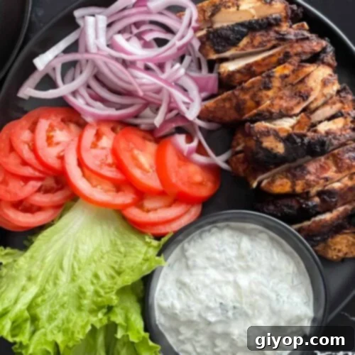 Grilled chicken shawarma on a dark plate.