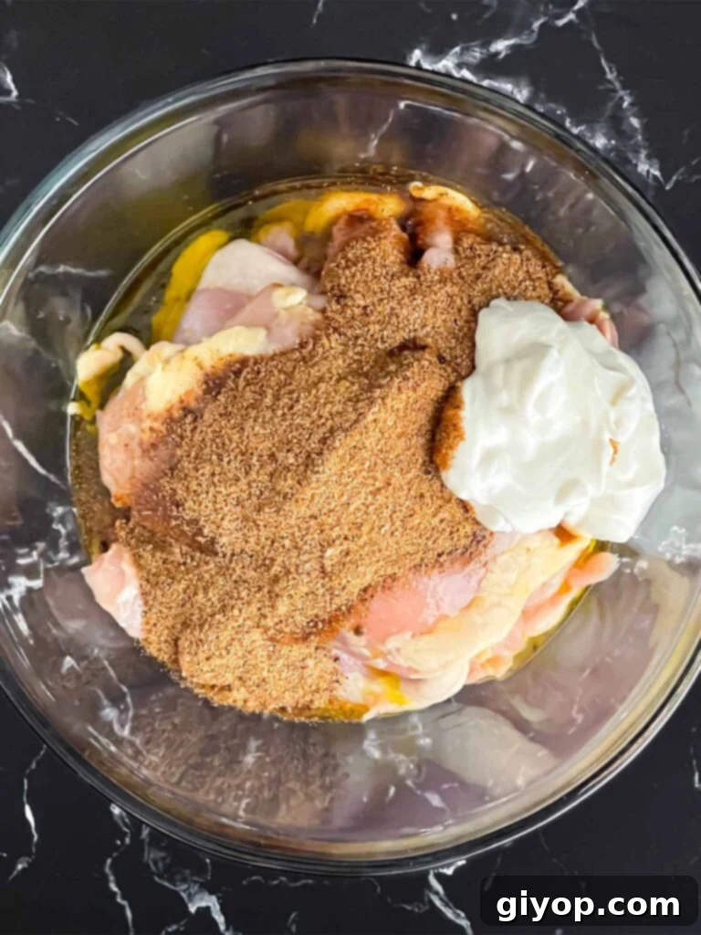 Chicken thighs added to a marinade.