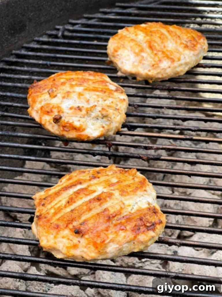 Perfectly grilled chicken burgers with distinct grill marks.