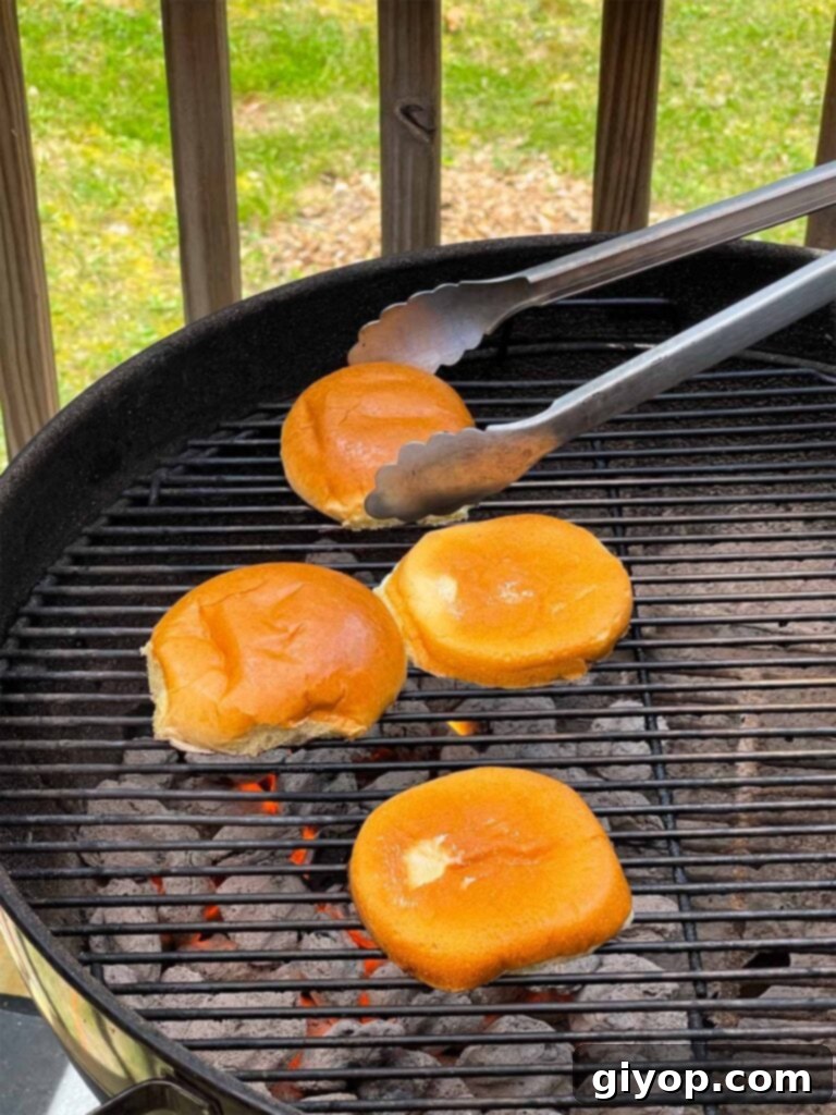 Hamburger buns being toasted on the grill to a golden crisp.