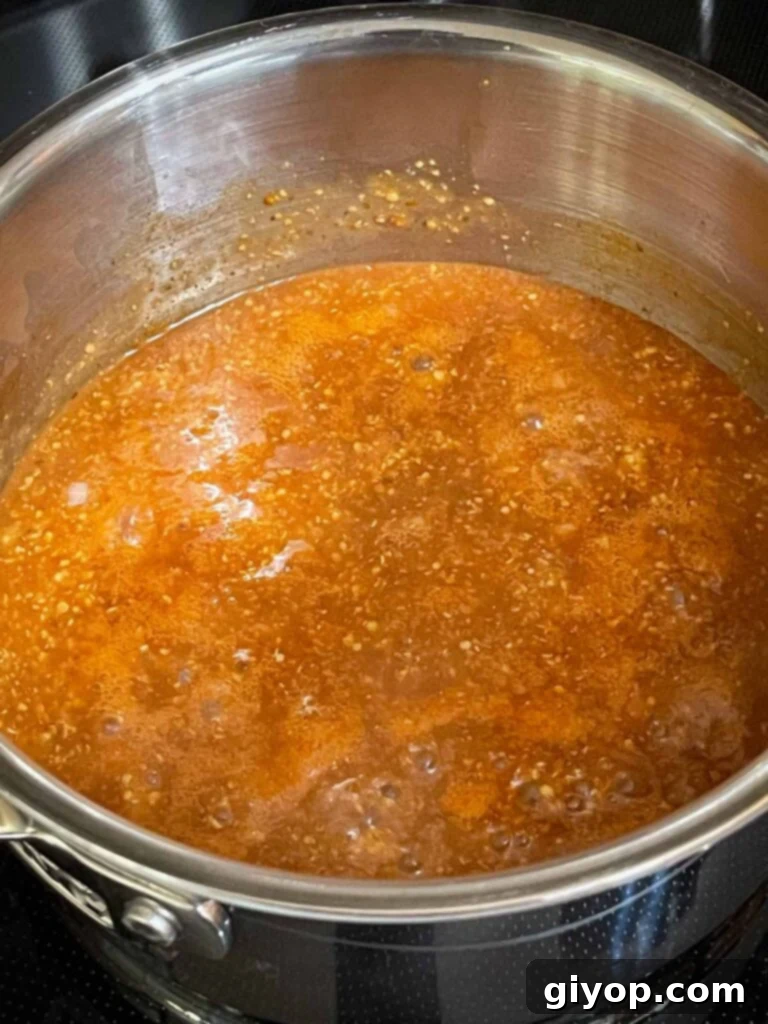 Barbecue sauce simmering in a saucepan on the stove.