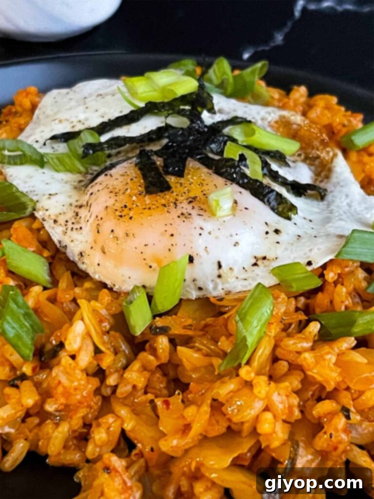 Kimchi fried rice topped with green onion, and gim.