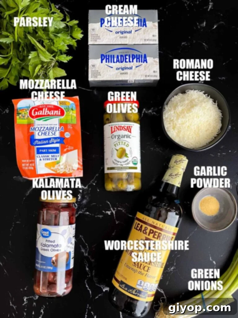 Mediterranean Olive Cheese Ball 3 Fresh ingredients for the olive cheese ball recipe laid out on a dark surface, including cream cheese, olives, and various cheeses.