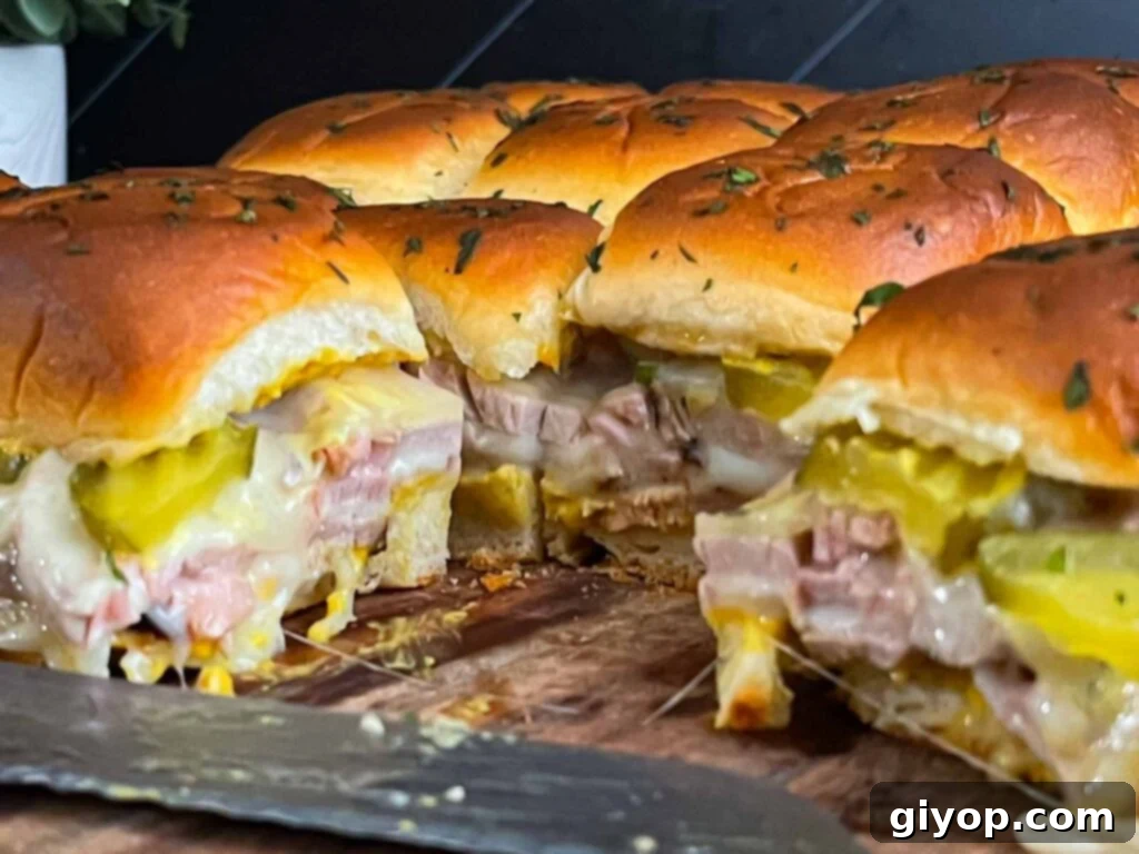 Close-up of freshly grilled roll-cut pork tenderloin Cuban sliders with melted cheese.