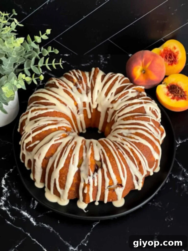 The finished peach pound cake, beautifully glazed and presented on a dark plate, ready to be enjoyed.