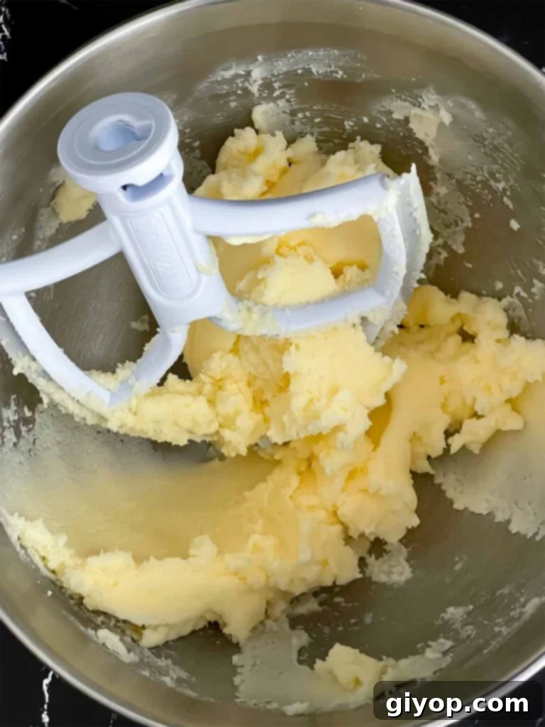 Creamed butter and sugar in a metal mixing bowl, forming the base of the peach pound cake batter.