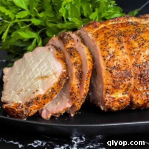 Texan Pit Smoked Pork Loin 14 A Texas style smoked pork loin on a black serving plate.