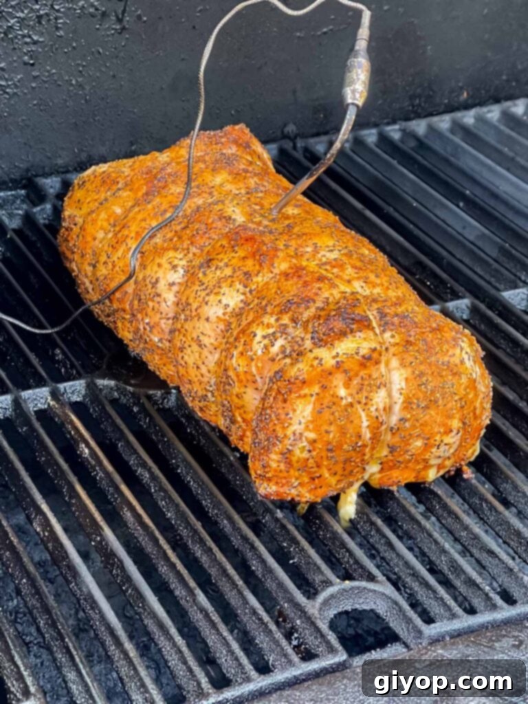 Texan Pit Smoked Pork Loin 6 A Texas style smoked pork loin on a smoker with a temperature probe inserted.