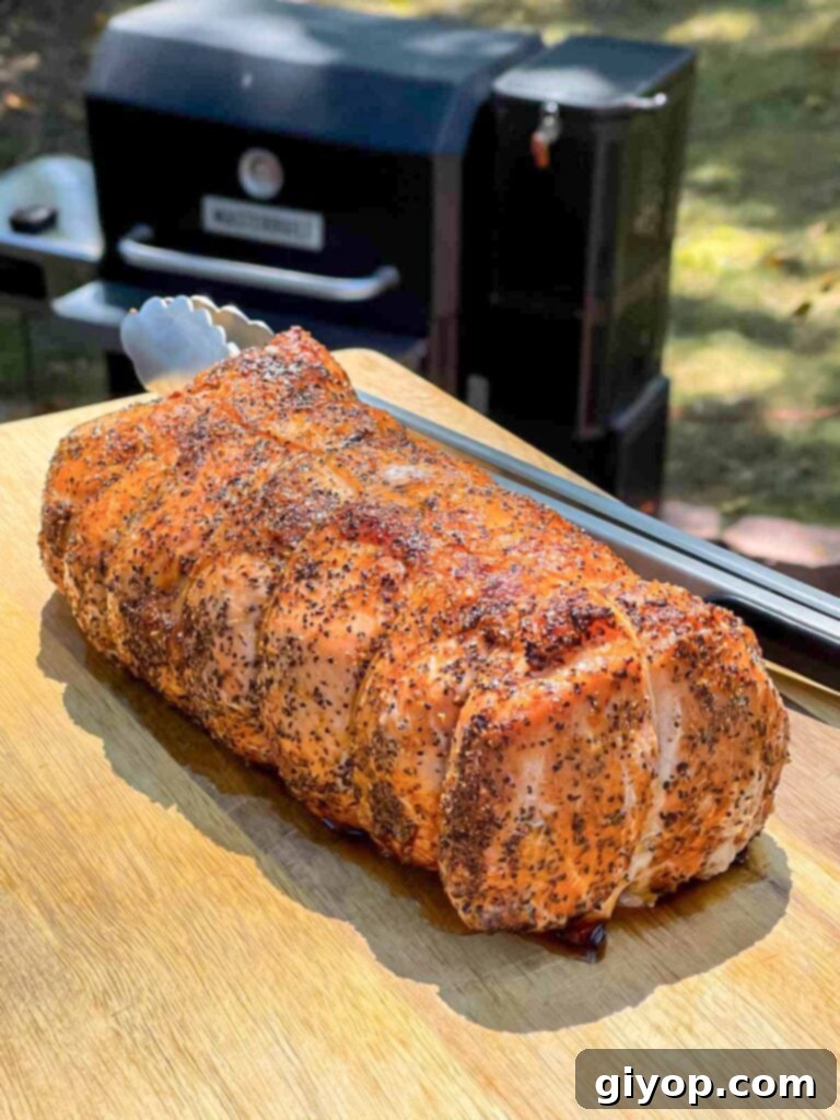 Texan Pit Smoked Pork Loin 8 A Texas style smoked pork loin on cutting board.