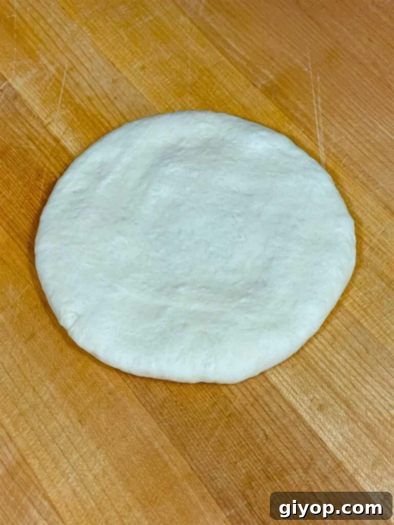 A portion of calzone dough, lightly floured and ready to be rolled out.
