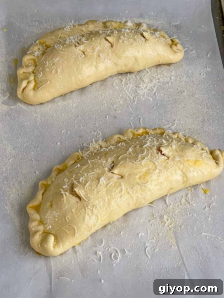 Calzones brushed with egg wash and vented, ready to be baked.