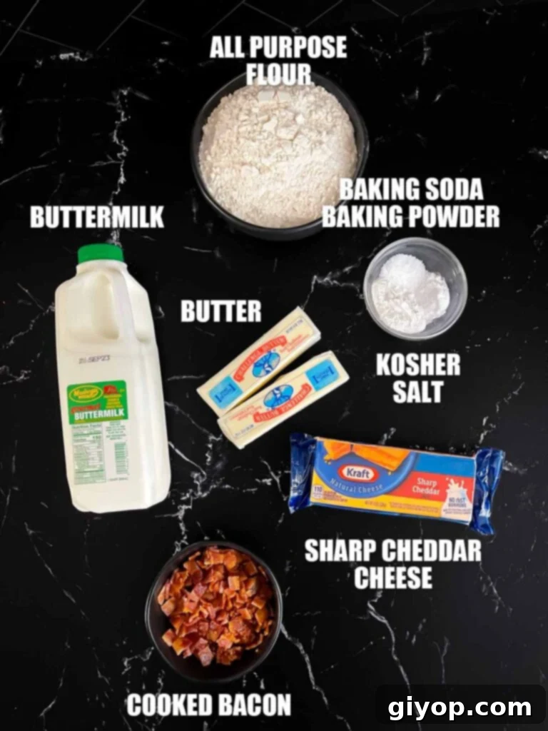 Smoky Bacon Cheddar Delights 3 Bacon cheddar biscuits recipe ingredients laid out on a dark surface, including flour, butter, bacon, and cheddar cheese.