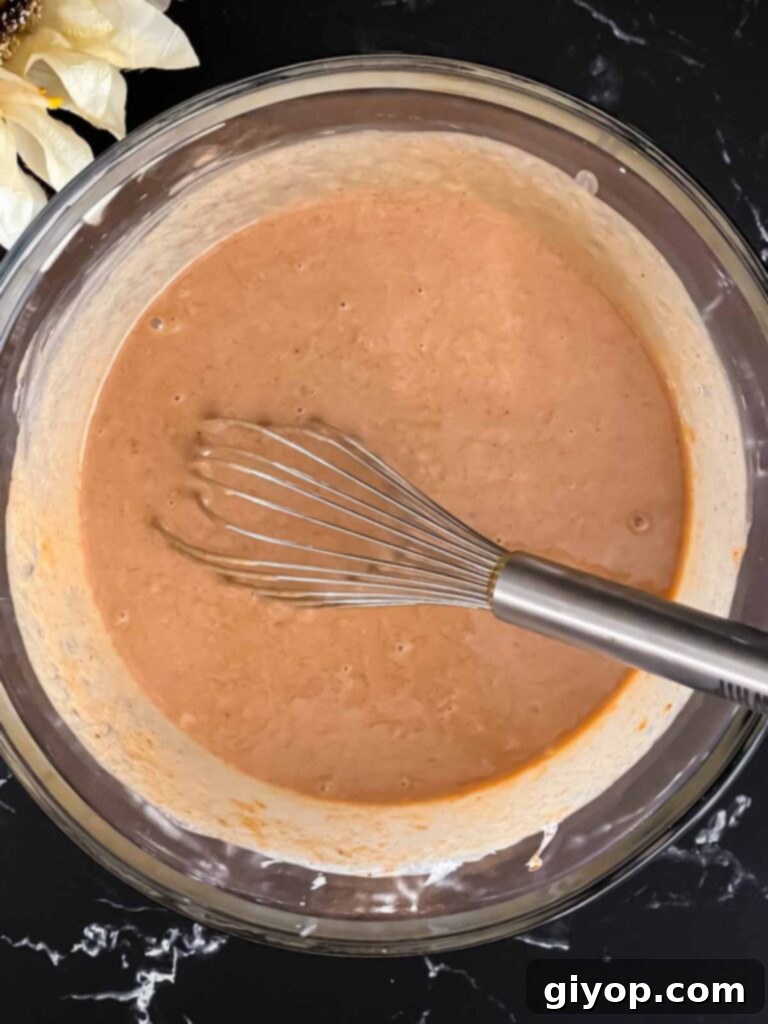 A bowl of apple butter pie filling, perfectly whisked until smooth and creamy, ready to be poured into the pie crust.