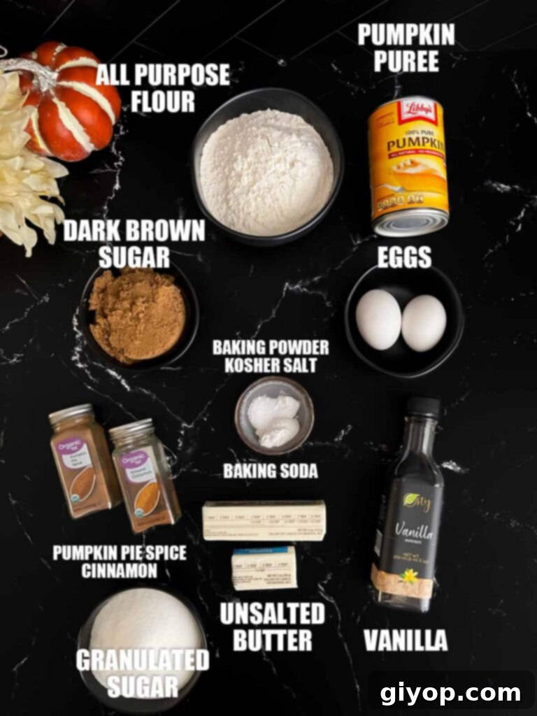 Baked pumpkin donuts recipe ingredients laid out on a dark surface.