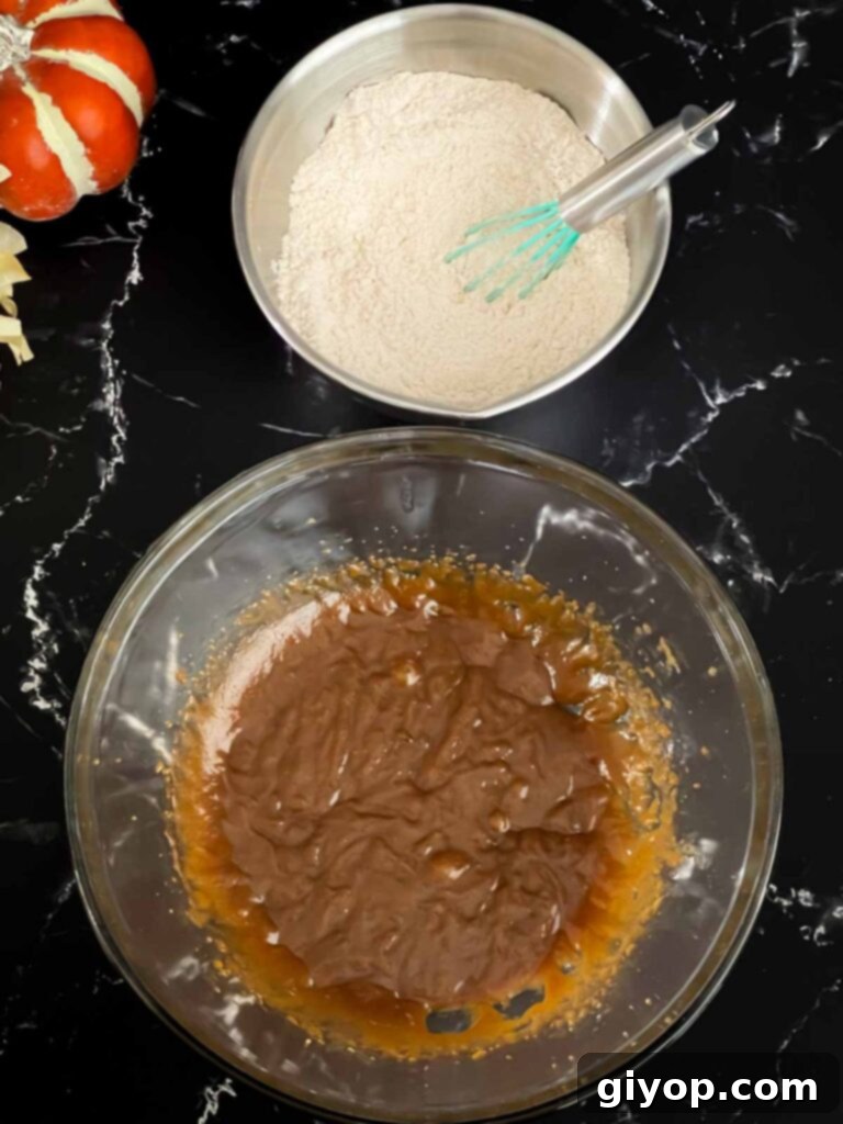 Baked pumpkin donuts wet batter in a glass bowl and dry ingredients in a metal bowl.