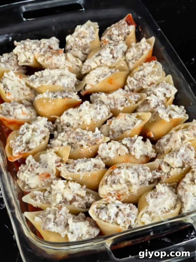 Unbaked Italian stuffed shells in a casserole dish.