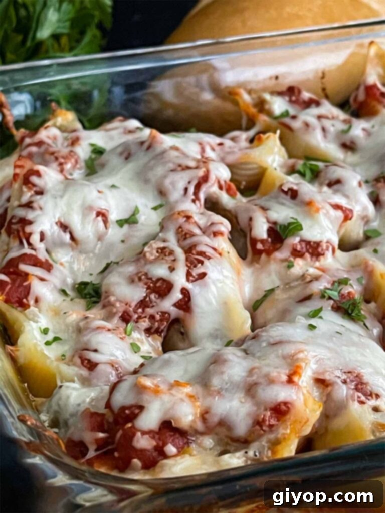 Italian sausage stuffed shells with bread in the background.