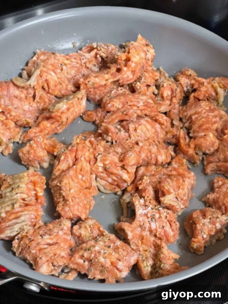 Seasoned Italian sausage in a skillet.