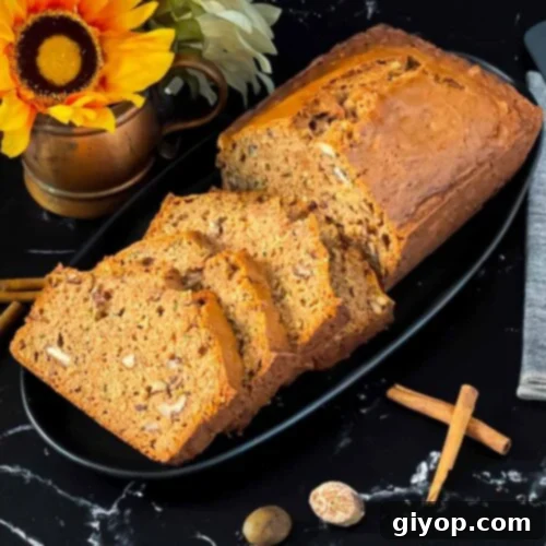 Sliced zucchini bread loaf on a dark oval platter on a dark surface.