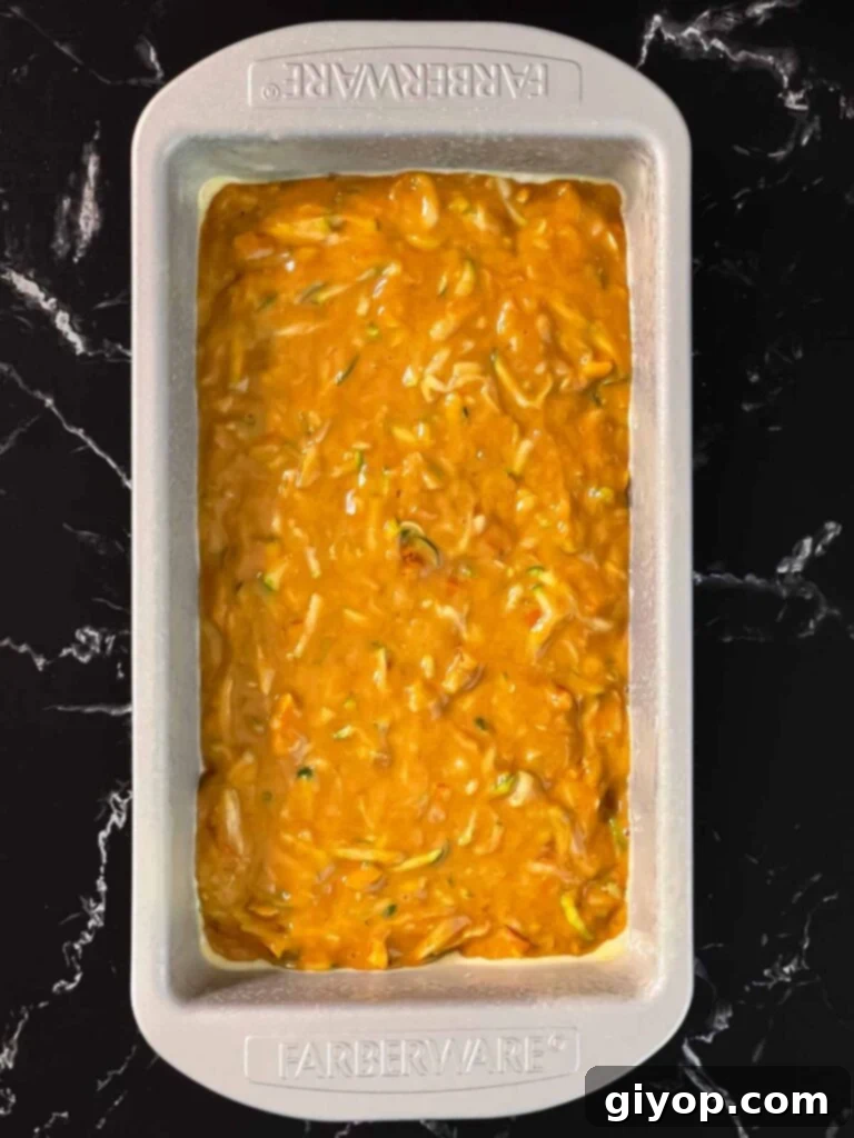 Zucchini bread batter in a greased loaf pan.