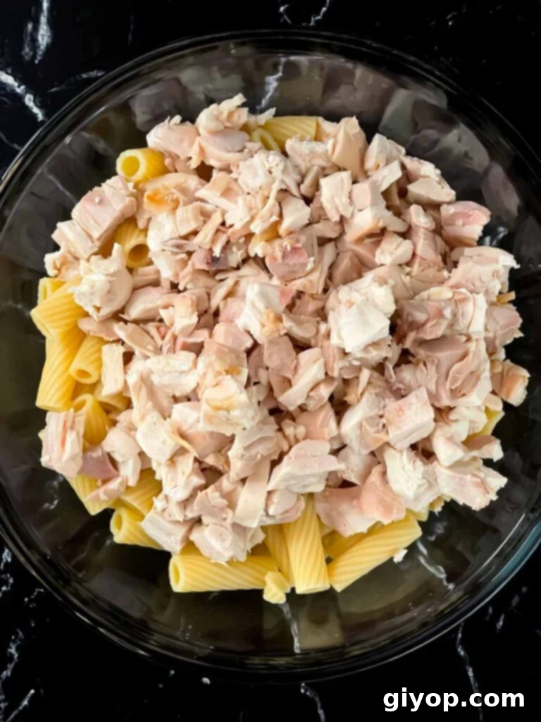 Chicken and pasta in a glass bowl.