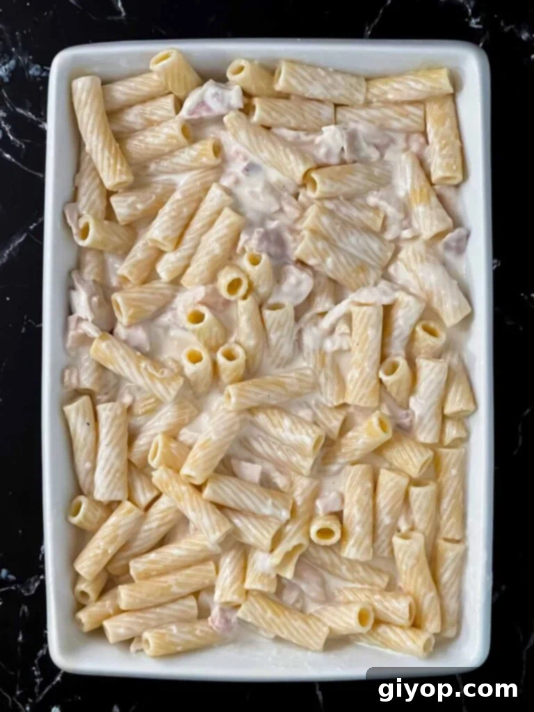 Unbaked Chicken Alfredo Casserole in a white casserole dish.