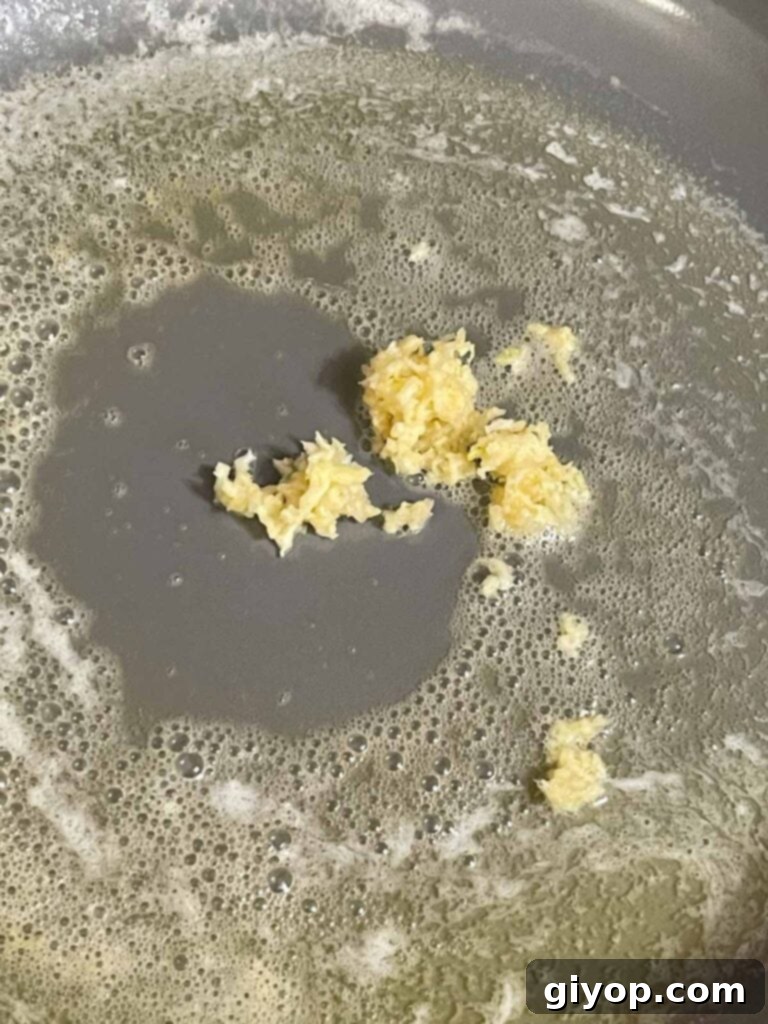 Adding garlic to butter in a skillet.