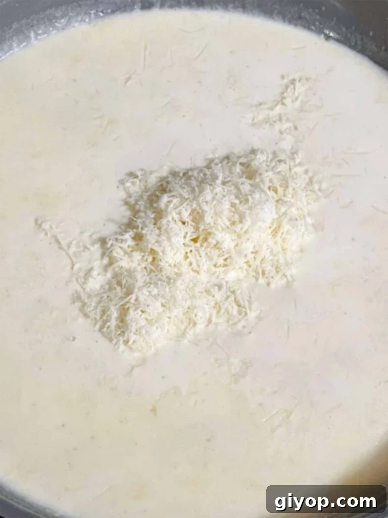 Adding parmesan cheese to a sauce.