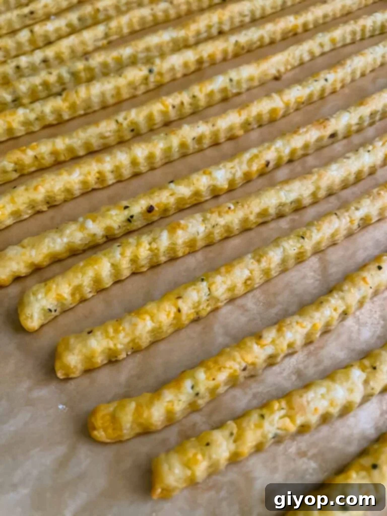 Savory Cheddar Herb Twists 14 A closer look at the perfectly baked and golden-brown cheddar cheese and herb straws on a baking sheet.