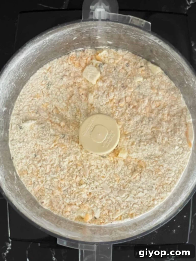 Savory Cheddar Herb Twists 7 A cohesive dough forming in the food processor bowl after adding heavy cream to the butter and flour mixture.