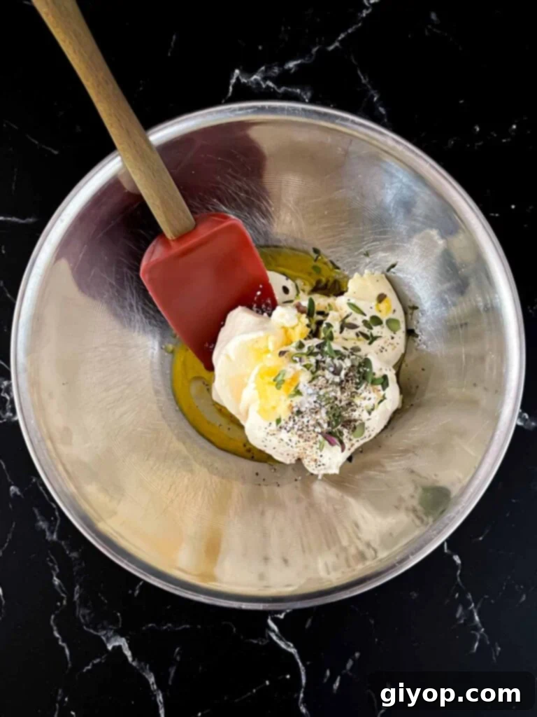 All the creamy ricotta dip ingredients, including ricotta cheese, garlic, lemon, and herbs, gathered in a mixing bowl before combining.