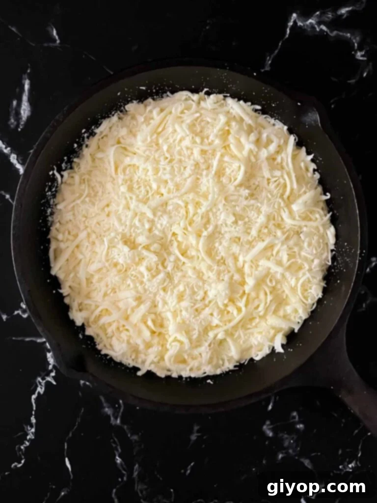 The ricotta dip in a cast iron skillet, generously topped with a blend of mozzarella and Romano cheeses.