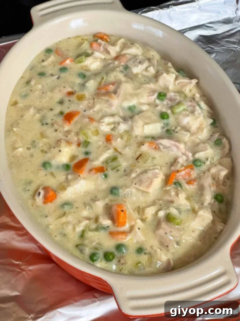 Creamy chicken and vegetable mixture spread evenly in a baking dish.