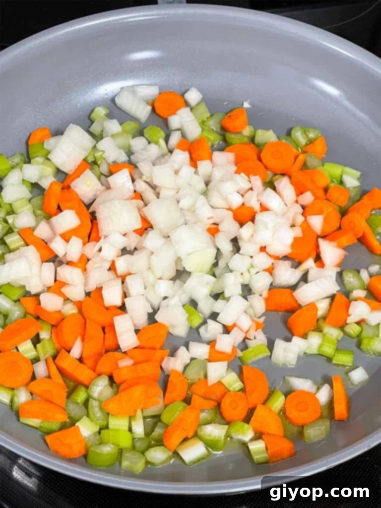 Freshly diced mirepoix (onions, celery, carrots) in a skillet.