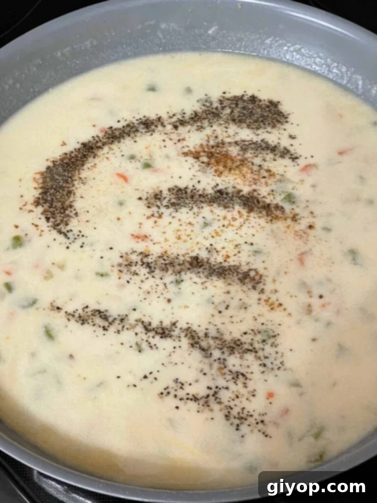 The creamy sauce for chicken stuffing casserole simmering in a skillet.